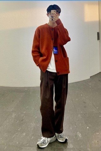 Teenager: Outfits Herren 2024: Kombinieren Sie eine orange Strickjacke mit einer dunkelbraunen Chinohose für einen bequemen Alltags-Look. Warum kombinieren Sie Ihr Outfit für einen legereren Auftritt nicht mal mit grauen Sportschuhen?