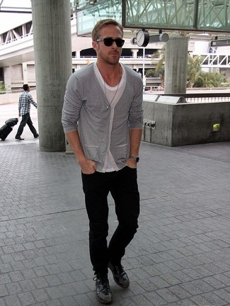 Ryan Gosling trägt weiße und schwarze horizontal gestreifte Strickjacke, graues T-Shirt mit einem Rundhalsausschnitt, schwarze Jeans, schwarze Lederfreizeitstiefel