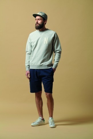 Mintgrünes Sweatshirts kombinieren – 2 Sommer Herren Outfits: Kombinieren Sie ein mintgrünes Sweatshirts mit dunkelblauen Shorts, um mühelos alles zu meistern, was auch immer der Tag bringen mag. Weiße und grüne Leder niedrige Sneakers fügen sich nahtlos in einer Vielzahl von Outfits ein. Dieser Look ist super für den Sommer geeignet.