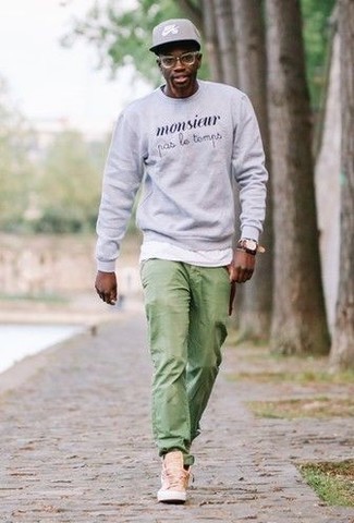 graues bedrucktes Sweatshirt, weißes T-Shirt mit einem Rundhalsausschnitt, grüne Chinohose, beige hohe Sneakers aus Segeltuch für Herren