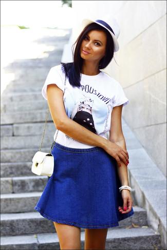 weißes bedrucktes T-Shirt mit einem Rundhalsausschnitt, blauer Jeans A-Linienrock, weiße Leder Umhängetasche, weißer Strohhut für Damen