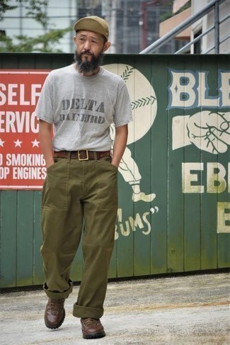 graues bedrucktes T-Shirt mit einem Rundhalsausschnitt, olivgrüne Chinohose, dunkelbraune Lederarbeitsstiefel, beige Baseballkappe für Herren