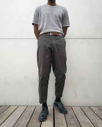 graues T-Shirt mit einem Rundhalsausschnitt, dunkelgraue Chinohose, schwarze Leder Derby Schuhe, brauner Ledergürtel für Herren
