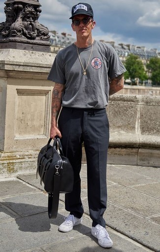 graues bedrucktes T-Shirt mit einem Rundhalsausschnitt, dunkelgraue Chinohose, weiße Segeltuch niedrige Sneakers, schwarze Leder Sporttasche für Herren