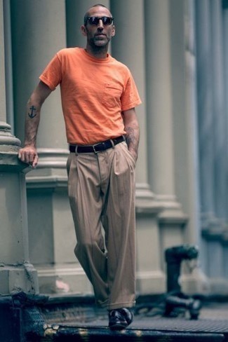 Schwarze Leder Slipper kombinieren – 157 Herren Outfits heiß Wetter: Kombinieren Sie ein orange T-Shirt mit einem Rundhalsausschnitt mit einer braunen vertikal gestreiften Chinohose für ein Alltagsoutfit, das Charakter und Persönlichkeit ausstrahlt. Setzen Sie bei den Schuhen auf die klassische Variante mit schwarzen Leder Slippern.