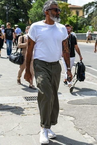 50 Jährige: Dunkelgrüne Hose kombinieren – 9 Herren Outfits heiß Wetter: Kombinieren Sie ein weißes T-Shirt mit einem Rundhalsausschnitt mit einer dunkelgrünen Hose für einen bequemen Alltags-Look. Fühlen Sie sich mutig? Wählen Sie weißen Sportschuhe.