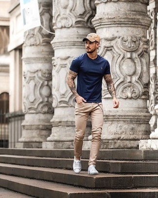 Hellbeige Jeans kombinieren – 500+ Herren Outfits: Kombinieren Sie ein dunkelblaues T-Shirt mit einem Rundhalsausschnitt mit hellbeige Jeans für ein bequemes Outfit, das außerdem gut zusammen passt. Weiße Segeltuch niedrige Sneakers sind eine großartige Wahl, um dieses Outfit zu vervollständigen.