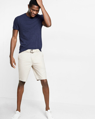 Hellbeige Segeltuchgürtel kombinieren – 49 Casual Sommer Herren Outfits: Entscheiden Sie sich für Komfort in einem dunkelblauen T-Shirt mit einem Rundhalsausschnitt und einem hellbeige Segeltuchgürtel. Ergänzen Sie Ihr Outfit mit weißen niedrigen Sneakers, um Ihr Modebewusstsein zu zeigen. Dieses Outfit eignet sich hervorragend für den Sommer.