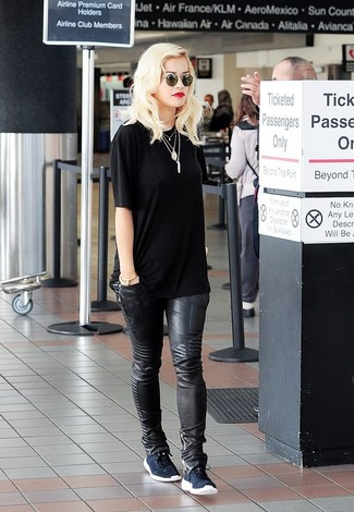 Rita Ora trägt schwarzes T-Shirt mit einem Rundhalsausschnitt, schwarze Leder enge Jeans, dunkelblaue niedrige Sneakers, schwarze Sonnenbrille