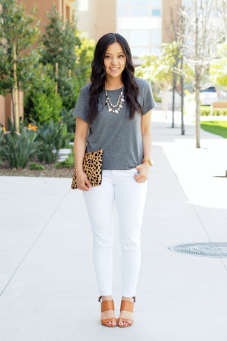 graues T-Shirt mit einem Rundhalsausschnitt, weiße enge Jeans, beige Leder Sandaletten, beige Wildleder Clutch mit Leopardenmuster für Damen