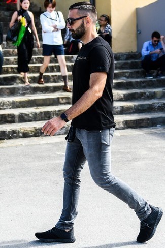 schwarzes und weißes bedrucktes T-Shirt mit einem Rundhalsausschnitt, graue enge Jeans, schwarze Sportschuhe, schwarze Sonnenbrille für Herren