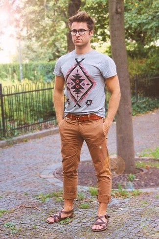 graues bedrucktes T-Shirt mit einem Rundhalsausschnitt, braune Chinohose, dunkelbraune Ledersandalen, rotbrauner Ledergürtel für Herren