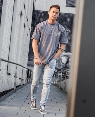 graues bedrucktes T-Shirt mit einem Rundhalsausschnitt, graue enge Jeans mit Destroyed-Effekten, dunkelbraune Segeltuch niedrige Sneakers, silbernes Armband für Herren