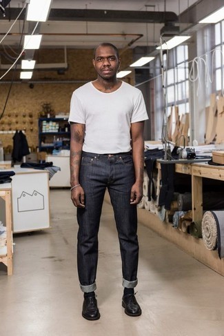 Jeans kombinieren – 137 Smart-Casual Herren Outfits heiß Wetter: Entscheiden Sie sich für ein weißes T-Shirt mit einem Rundhalsausschnitt und Jeans für ein bequemes Outfit, das außerdem gut zusammen passt. Fühlen Sie sich ideenreich? Komplettieren Sie Ihr Outfit mit schwarzen Leder Derby Schuhen.