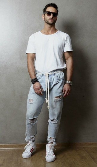 weißes T-Shirt mit einem Rundhalsausschnitt, hellblaue Jeans mit Destroyed-Effekten, weiße hohe Sneakers aus Leder, dunkelbraune Sonnenbrille für Herren