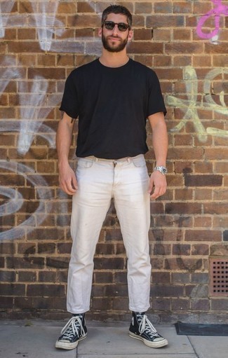 schwarzes T-Shirt mit einem Rundhalsausschnitt, weiße Jeans, dunkelblaue und weiße hohe Sneakers aus Segeltuch, schwarze Sonnenbrille für Herren