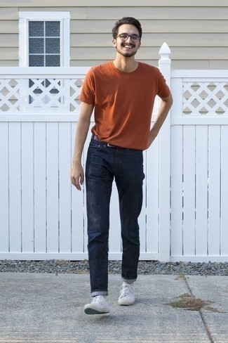 Orange T-Shirt mit einem Rundhalsausschnitt kombinieren – 238 Casual Herren Outfits: Tragen Sie ein orange T-Shirt mit einem Rundhalsausschnitt und dunkelblauen Jeans, um einen lockeren, aber dennoch stylischen Look zu erhalten. Weiße Segeltuch niedrige Sneakers sind eine gute Wahl, um dieses Outfit zu vervollständigen.