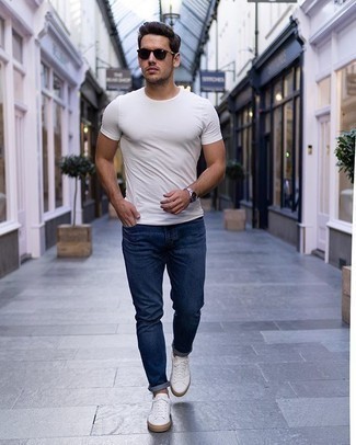 Wie weißes T-Shirt mit einem Rundhalsausschnitt mit dunkelblauer Jeans zu kombinieren – 500+ Herren Outfits: Kombinieren Sie ein weißes T-Shirt mit einem Rundhalsausschnitt mit dunkelblauen Jeans für ein bequemes Outfit, das außerdem gut zusammen passt. Weiße Segeltuch niedrige Sneakers sind eine ideale Wahl, um dieses Outfit zu vervollständigen.