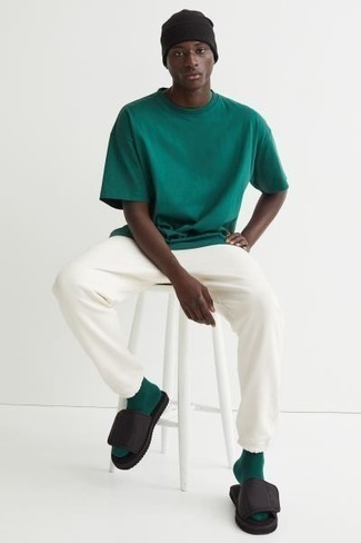 Dunkelgrünes T-Shirt mit einem Rundhalsausschnitt kombinieren – 488 Herren Outfits: Paaren Sie ein dunkelgrünes T-Shirt mit einem Rundhalsausschnitt mit einer weißen Jogginghose für einen entspannten Wochenend-Look. Fühlen Sie sich ideenreich? Wählen Sie schwarzen Segeltuchsandalen.