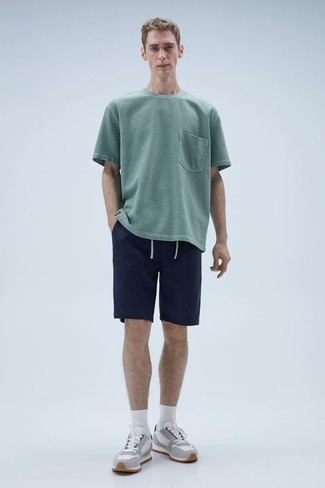 Sommer Outfits Herren 2024: Kombinieren Sie ein mintgrünes T-Shirt mit einem Rundhalsausschnitt mit dunkelblauen Shorts, um einen lockeren, aber dennoch stylischen Look zu erhalten. Wenn Sie nicht durch und durch formal auftreten möchten, komplettieren Sie Ihr Outfit mit grauen Sportschuhen. Schon ergibt sich ein toller Sommer-Look.