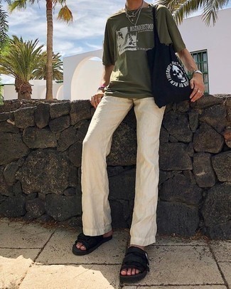 olivgrünes bedrucktes T-Shirt mit einem Rundhalsausschnitt, hellbeige Leinen Chinohose, schwarze Segeltuchsandalen, schwarze und weiße bedruckte Shopper Tasche aus Segeltuch für Herren