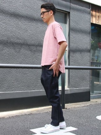 Rosa T-Shirt mit einem Rundhalsausschnitt kombinieren – 245 Herren Outfits: Kombinieren Sie ein rosa T-Shirt mit einem Rundhalsausschnitt mit dunkelblauen Jeans, um mühelos alles zu meistern, was auch immer der Tag bringen mag. Weiße Segeltuch niedrige Sneakers sind eine perfekte Wahl, um dieses Outfit zu vervollständigen.