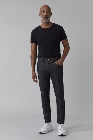 schwarzes T-Shirt mit einem Rundhalsausschnitt, dunkelgraue Jeans, weiße Sportschuhe, weiße Socken für Herren