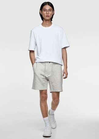 Weiße Shorts kombinieren – 109 Casual Herren Outfits heiß Wetter: Kombinieren Sie ein weißes T-Shirt mit einem Rundhalsausschnitt mit weißen Shorts für ein Alltagsoutfit, das Charakter und Persönlichkeit ausstrahlt. Weiße Leder niedrige Sneakers sind eine perfekte Wahl, um dieses Outfit zu vervollständigen.