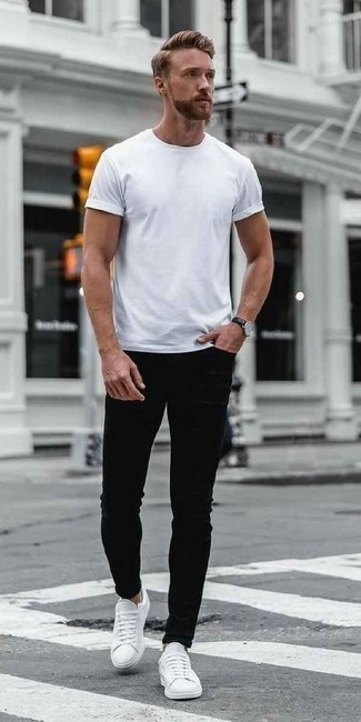 Schwarze Jeans kombinieren – 269 Lässige Sommer Herren Outfits: Entscheiden Sie sich für Komfort in einem weißen T-Shirt mit einem Rundhalsausschnitt und schwarzen Jeans. Weiße Segeltuch niedrige Sneakers sind eine perfekte Wahl, um dieses Outfit zu vervollständigen. Ein stylischer Look für den Sommer.
