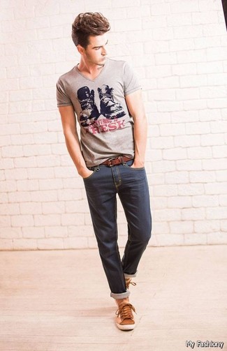 graues bedrucktes T-Shirt mit einem V-Ausschnitt, dunkelblaue enge Jeans, braune Leder niedrige Sneakers, brauner Ledergürtel für Herren