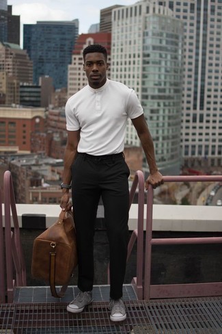 weißes T-shirt mit einer Knopfleiste, schwarze Chinohose, graue hohe Sneakers aus Segeltuch, braune Leder Reisetasche für Herren