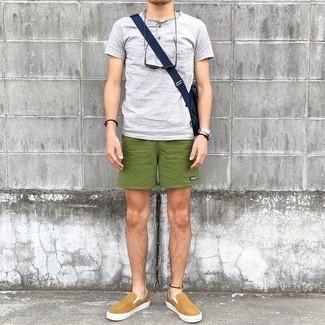 graues T-shirt mit einer Knopfleiste, olivgrüne Sportshorts, beige Slip-On Sneakers aus Segeltuch, dunkelblaue Segeltuch Umhängetasche für Herren