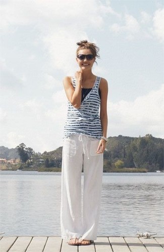 weißes und dunkelblaues horizontal gestreiftes Trägershirt, weiße Leinen weite Hose, hellbeige Zehentrenner, schwarze Sonnenbrille für Damen