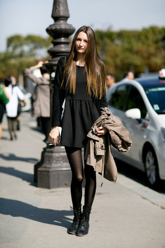 beige Trenchcoat, schwarzes Skaterkleid, schwarze flache Stiefel mit einer Schnürung aus Leder, schwarze Strumpfhose für Damen