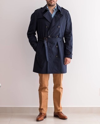 Braune Leder Brogues kombinieren – 500+ Herren Outfits: Entscheiden Sie sich für einen dunkelblauen Trenchcoat und eine rotbraune Chinohose für Drinks nach der Arbeit. Braune Leder Brogues bringen Eleganz zu einem ansonsten schlichten Look.