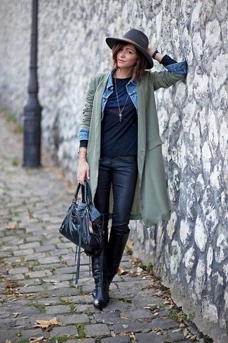 olivgrüner leichter Trenchcoat, hellblaue Jeansjacke, schwarzes bedrucktes Langarmshirt, schwarze Leder enge Jeans für Damen