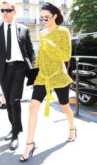 Kendall Jenner trägt gelbe Strick Tunika, schwarze Radlerhose, schwarze Leder Sandaletten, schwarze Wildleder Clutch