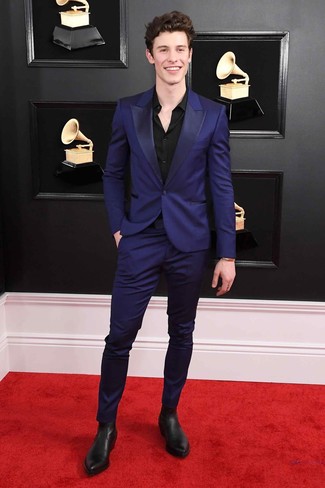 Shawn Mendes trägt violetter Anzug, schwarzes Businesshemd, schwarze Chelsea-Stiefel aus Leder