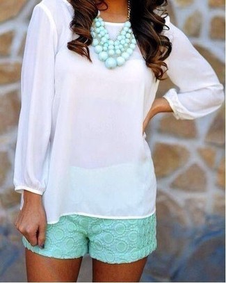 Mintgrüne Shorts kombinieren – 15 Damen Outfits: Um ein stilvolles, legeres Outfit zu schaffen, vereinigen Sie eine weiße Langarmbluse mit mintgrünen Shorts.