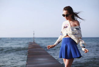 30 Jährige: Blauen Skaterrock kombinieren – 41 Smart-Casual Damen Outfits: Probieren Sie diese Kombi aus einer weißen Seide Langarmbluse mit Blumenmuster und einem blauen Skaterrock, um einen modischen Freizeit-Look zu zaubern.