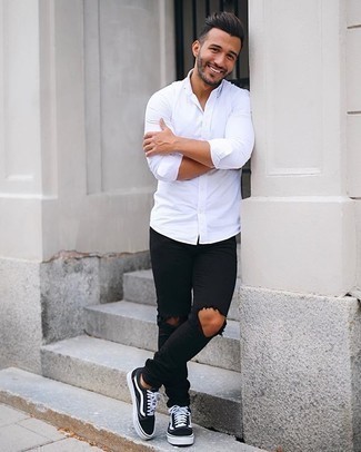 Schwarze enge Jeans kombinieren – 482 Lässige Herren Outfits: Kombinieren Sie ein weißes Langarmhemd mit schwarzen engen Jeans für einen entspannten Wochenend-Look. Schwarze und weiße Segeltuch niedrige Sneakers sind eine gute Wahl, um dieses Outfit zu vervollständigen.
