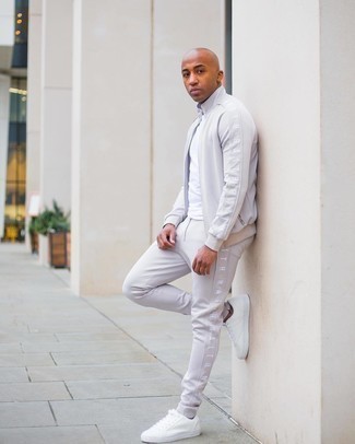 weißes T-Shirt mit einem Rundhalsausschnitt, grauer Trainingsanzug, weiße Segeltuch niedrige Sneakers für Herren