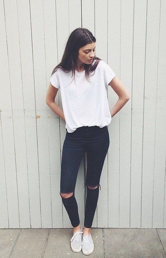 weißes T-Shirt mit einem Rundhalsausschnitt, schwarze enge Jeans mit Destroyed-Effekten, graue Segeltuch niedrige Sneakers für Damen