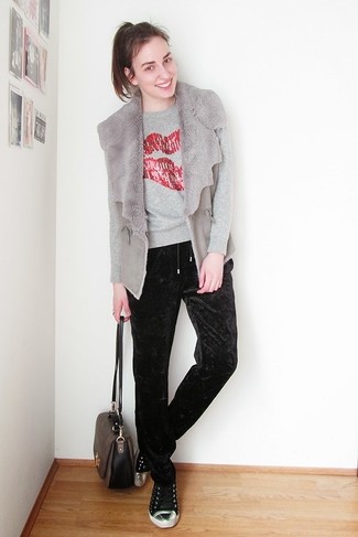 graue Pelzweste, grauer bedruckter Pullover mit einem Rundhalsausschnitt, schwarze Freizeithose aus Samt, schwarze niedrige Sneakers für Damen