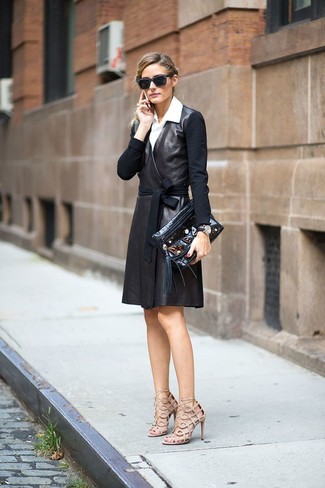 Olivia Palermo trägt schwarzes Wickelkleid aus Leder, weißes Businesshemd, hellbeige Leder Sandaletten, schwarze verzierte Leder Clutch