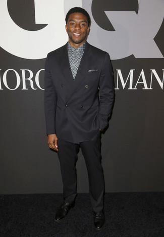 Chadwick Boseman trägt schwarzes Zweireiher-Sakko, graues Businesshemd mit Schottenmuster, schwarze Anzughose, schwarze Leder Derby Schuhe
