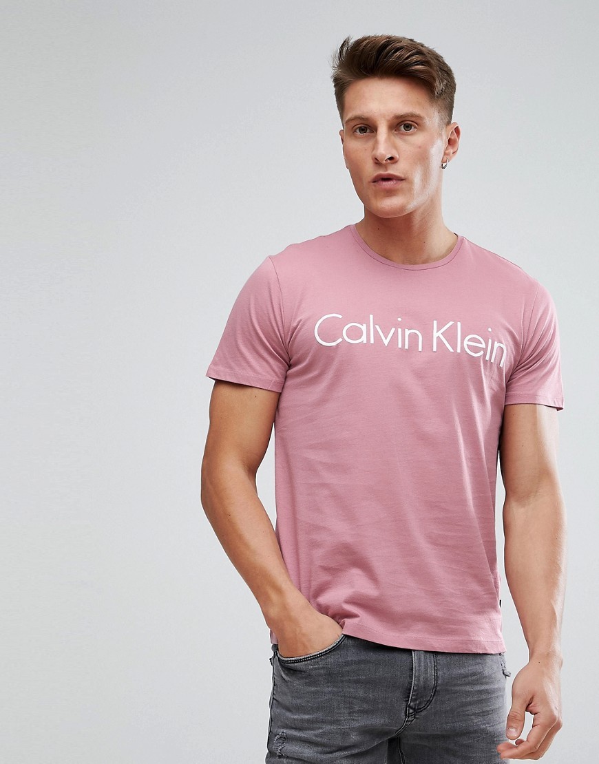 rosa bedrucktes T-Shirt einem mit Asos Calvin €32 | von Lookastic | Rundhalsausschnitt Klein
