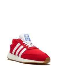 rote und weiße Sportschuhe von adidas