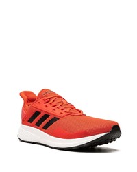 rote und weiße Sportschuhe von adidas