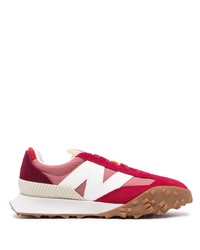 rote und weiße Sportschuhe von New Balance